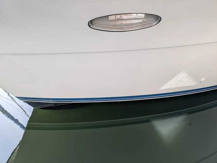 Infinity Bound Yacht Photos Pics Close-up of a 1991 Carver 430 Cockpit Motor Yacht hull reflecting on water.