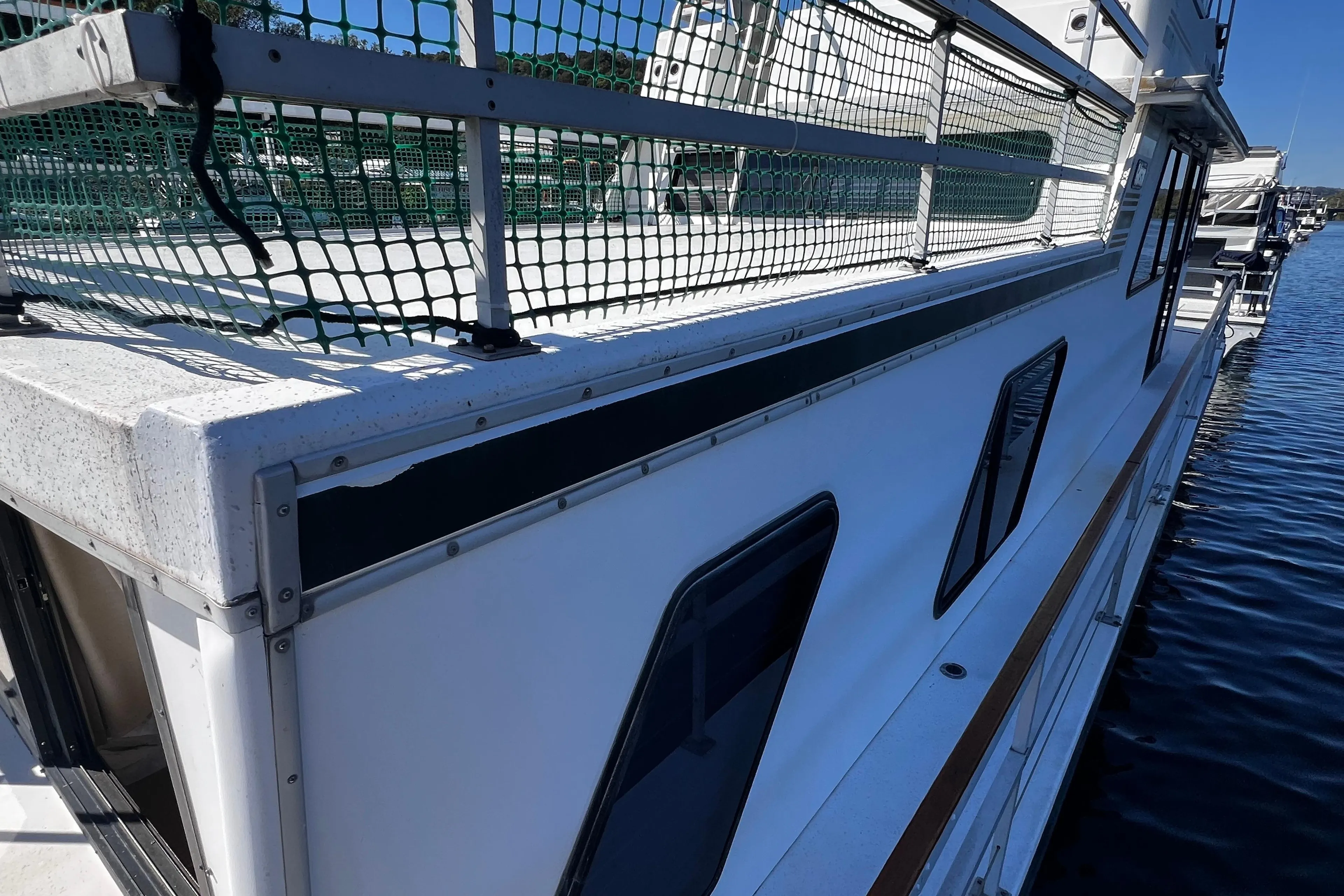Side view of a 1994 Gibson 44 Classic boat docked on calm water.