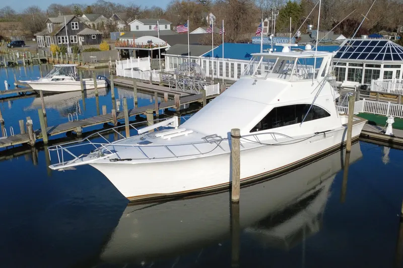 The Oar Deal Yacht Photos Pics 1999 Ocean Yachts 56 Super Sport docked at a marina, surrounded by calm waters.