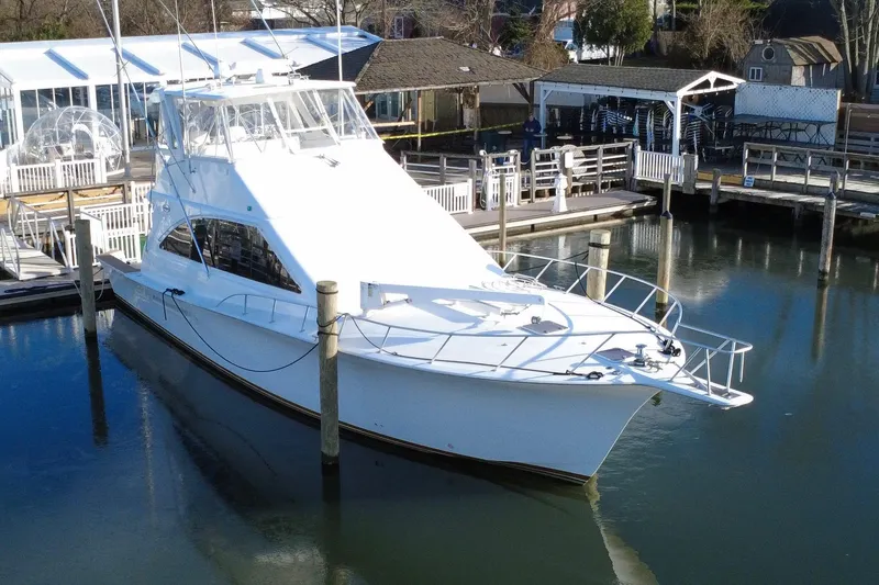 The Oar Deal Yacht Photos Pics 1999 Ocean Yachts 56 Super Sport docked at a marina, showcasing sleek design and luxury.