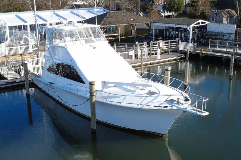 The Oar Deal Yacht Photos Pics 1999 Ocean Yachts 56 Super Sport docked at a marina, showcasing sleek design.