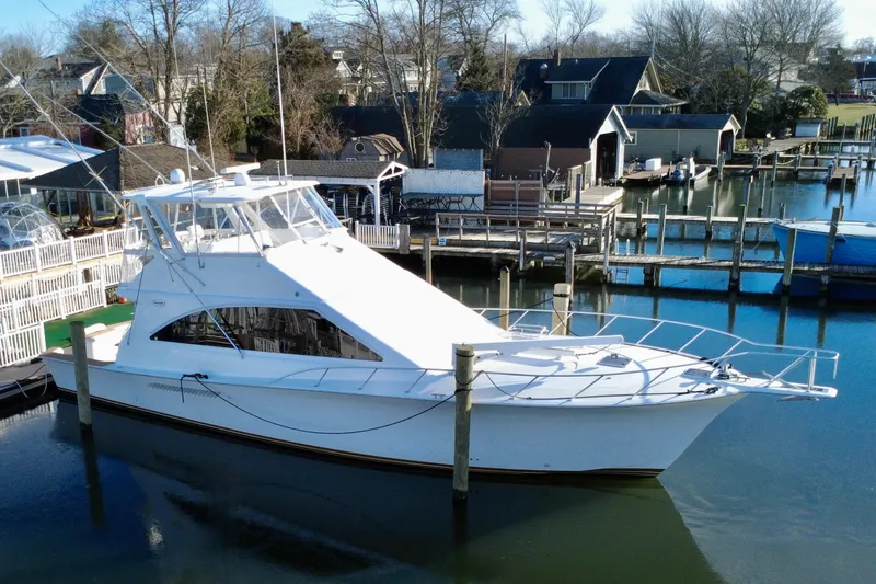 The Oar Deal Yacht Photos Pics 1999 Ocean Yachts 56 Super Sport docked in a serene marina setting.