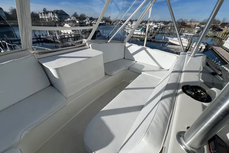 The Oar Deal Yacht Photos Pics 1999 Ocean Yachts 56 Super Sport yacht interior with white seating and marina view.