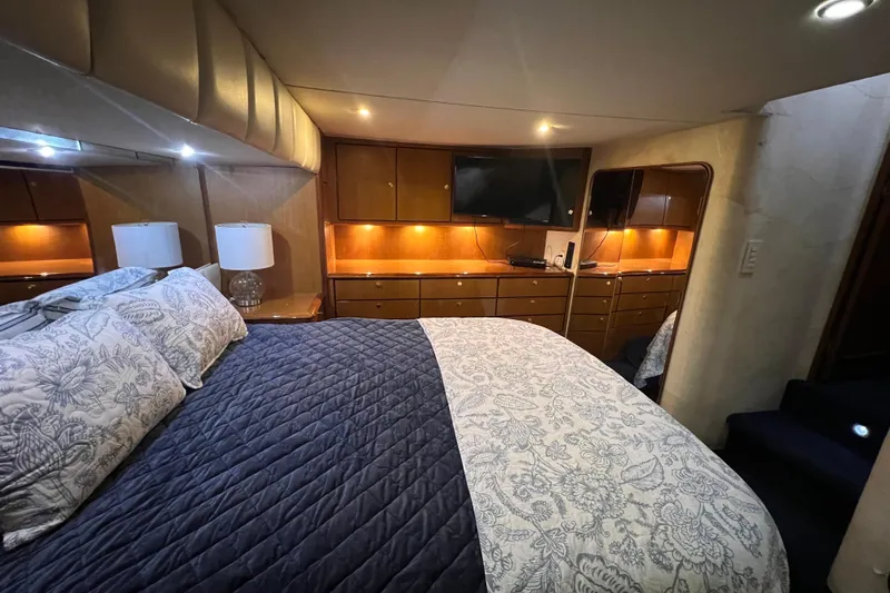 The Oar Deal Yacht Photos Pics Luxurious bedroom in 1999 Ocean Yachts 56 Super Sport with elegant bedding and ambient lighting.