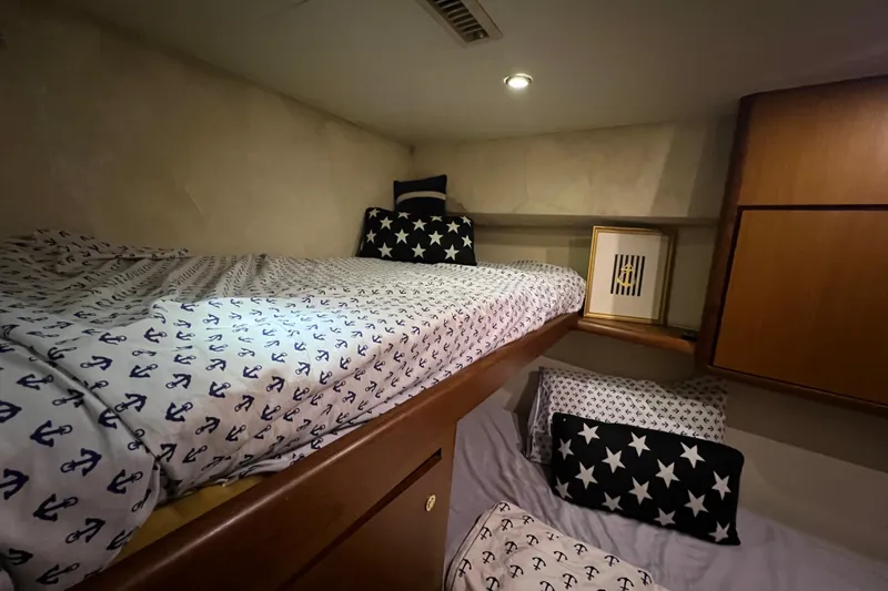 The Oar Deal Yacht Photos Pics Cozy cabin interior of 1999 Ocean Yachts 56 Super Sport with nautical-themed bedding.