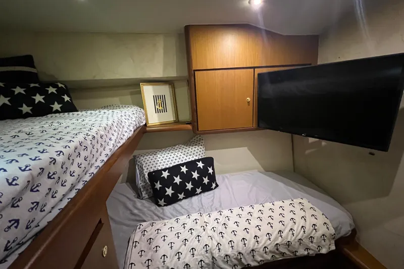 The Oar Deal Yacht Photos Pics Cozy cabin interior of 1999 Ocean Yachts 56 Super Sport with nautical-themed bedding.