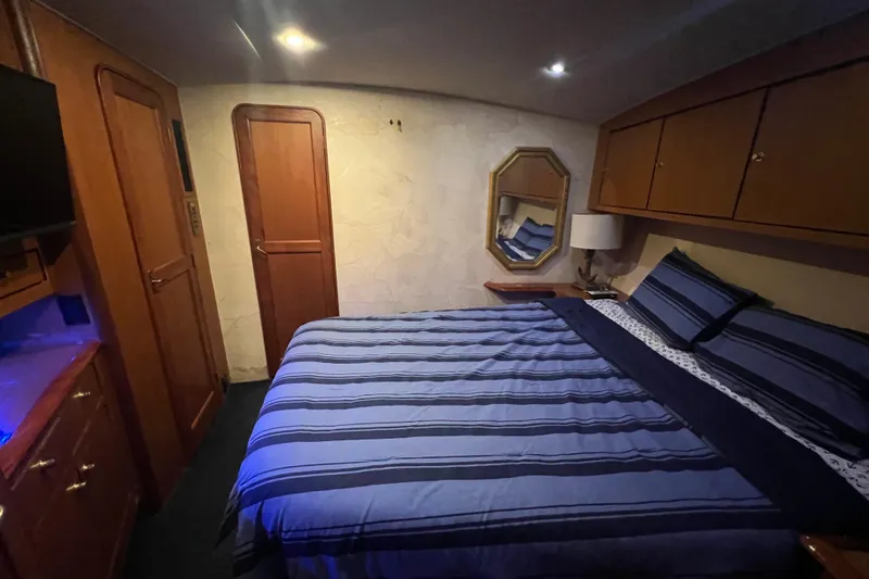 The Oar Deal Yacht Photos Pics Luxurious bedroom interior of 1999 Ocean Yachts 56 Super Sport with striped bedding.