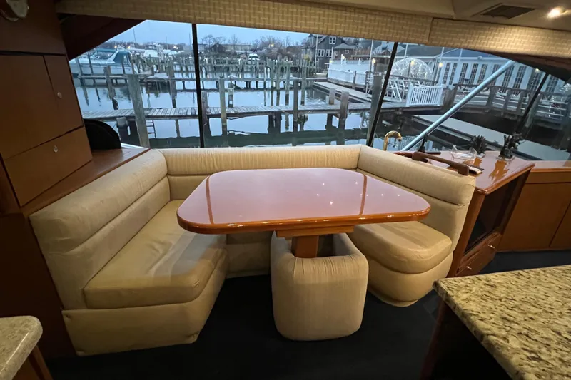 The Oar Deal Yacht Photos Pics Interior of 1999 Ocean Yachts 56 Super Sport with dining area and marina view.