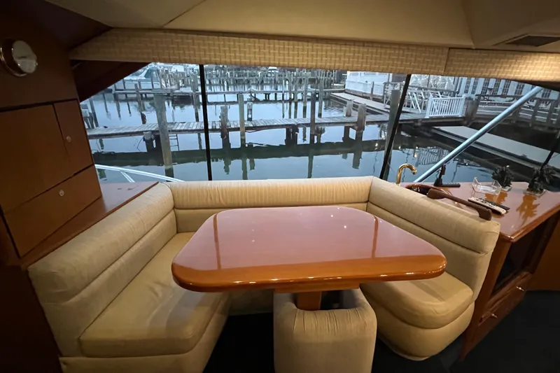 The Oar Deal Yacht Photos Pics Interior of 1999 Ocean Yachts 56 Super Sport with dining area and marina view.