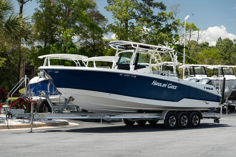  Yacht Photos Pics 2018 Wellcraft 302 Fisherman boat on trailer, parked outdoors.