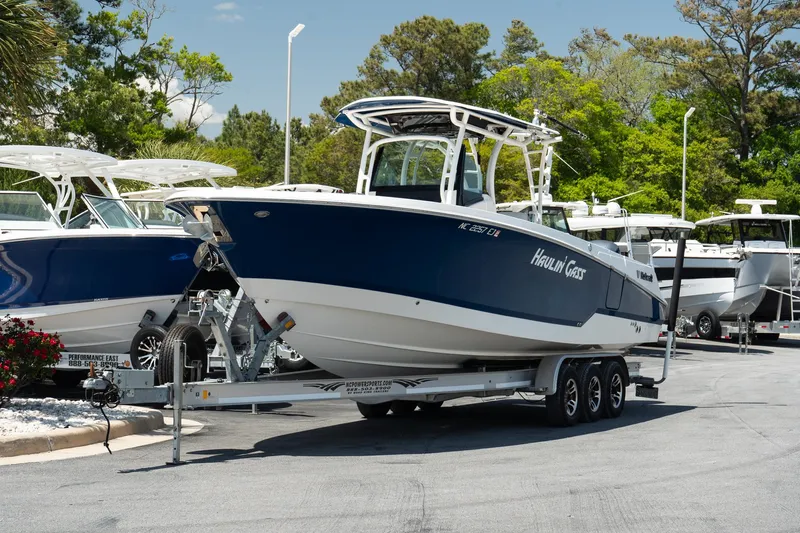  Yacht Photos Pics 2018 Wellcraft 302 Fisherman boat on trailer, parked outdoors in a marina setting.