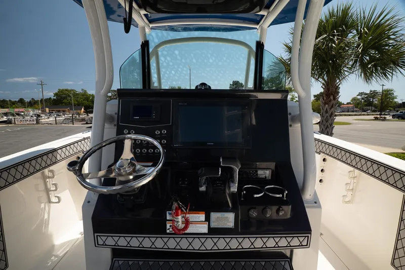  Yacht Photos Pics 2018 Wellcraft 302 Fisherman boat console with steering wheel and navigation controls.