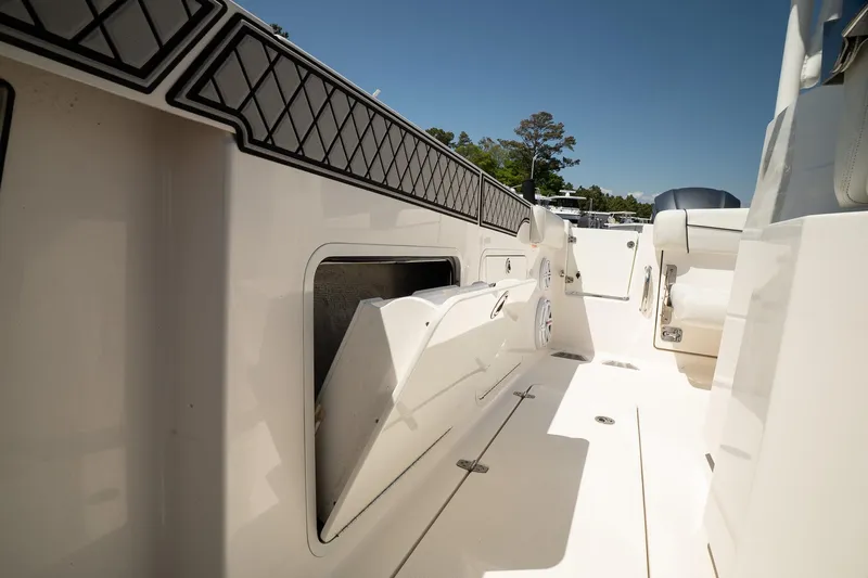  Yacht Photos Pics 2018 Wellcraft 302 Fisherman boat interior with open storage compartment, white seating, and sunny deck.