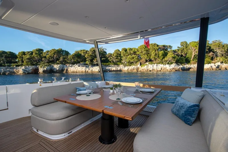  Yacht Photos Pics Luxurious dining area on 2025 Azimut Magellano 60 yacht, with scenic coastal view.