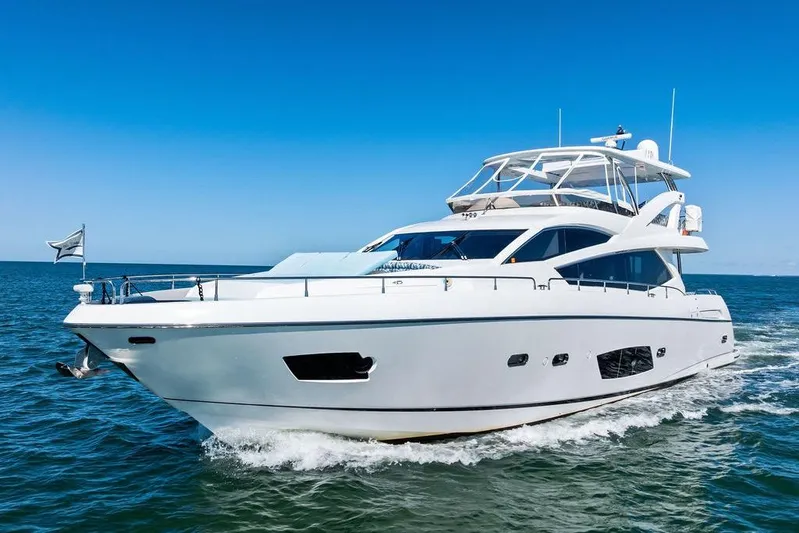 It's Enough Yacht Photos Pics Luxurious 2013 Sunseeker Manhattan 73 yacht cruising on open water under clear blue skies.