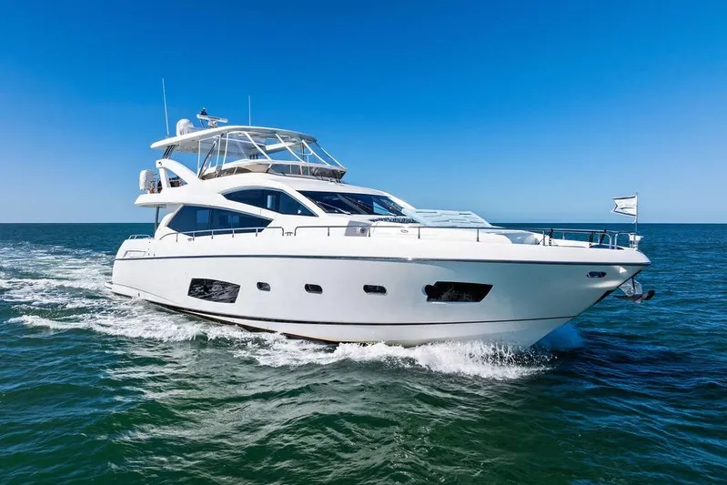 It's Enough Yacht Photos Pics 2013 Sunseeker Manhattan 73 yacht cruising on open sea under clear blue sky.