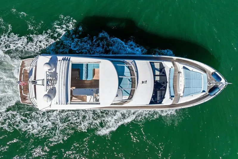It's Enough Yacht Photos Pics Aerial view of 2013 Sunseeker Manhattan 73 yacht cruising on green water.