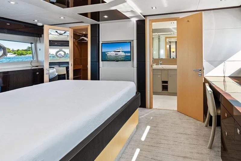 It's Enough Yacht Photos Pics Luxurious Sunseeker Manhattan 73 yacht bedroom interior with ensuite bathroom, elegant furnishings, and scenic window view.