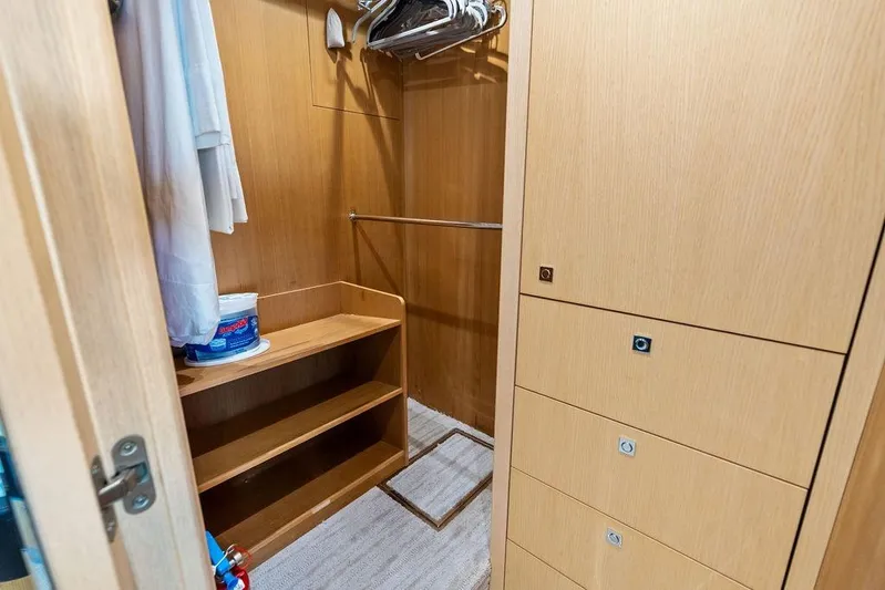 It's Enough Yacht Photos Pics Wooden closet interior on 2013 Sunseeker Manhattan 73 yacht, featuring shelves and hangers.