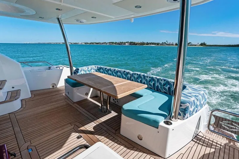 It's Enough Yacht Photos Pics Luxurious Sunseeker Manhattan 73 yacht deck with ocean view, featuring elegant seating and table.