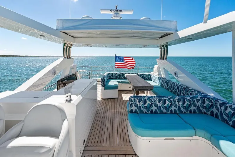 It's Enough Yacht Photos Pics Luxurious 2013 Sunseeker Manhattan 73 yacht deck with seating, ocean view, and American flag.