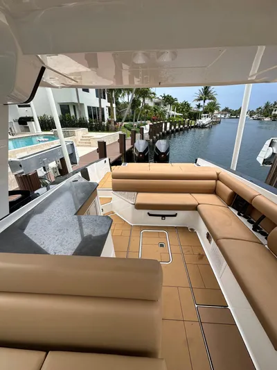  Yacht Photos Pics 2022 Aviara 32 yacht with spacious seating, docked by waterfront homes.