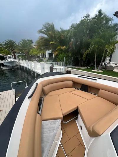 Yacht Photos Pics Luxurious 2022 Aviara 32 boat with tan seating, docked near tropical palm trees.