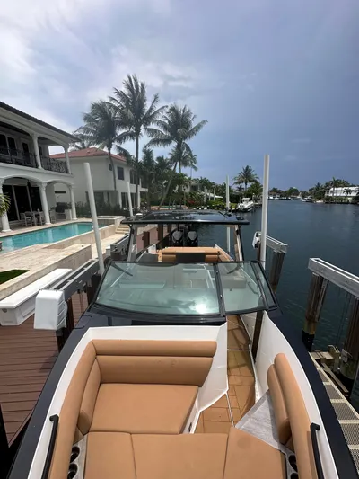  Yacht Photos Pics 2022 Aviara 32 boat docked by waterfront luxury home with pool and palm trees.