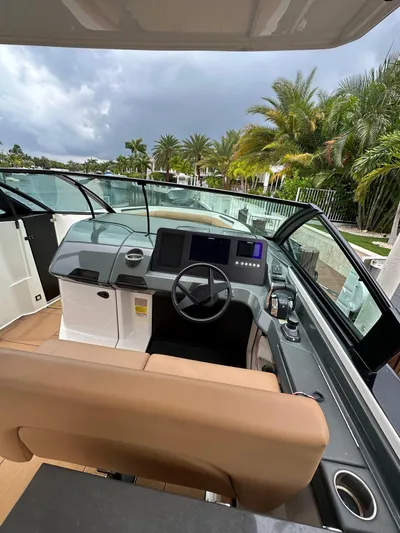  Yacht Photos Pics 2022 Aviara 32 boat cockpit with modern controls, sleek design, and palm trees in the background.