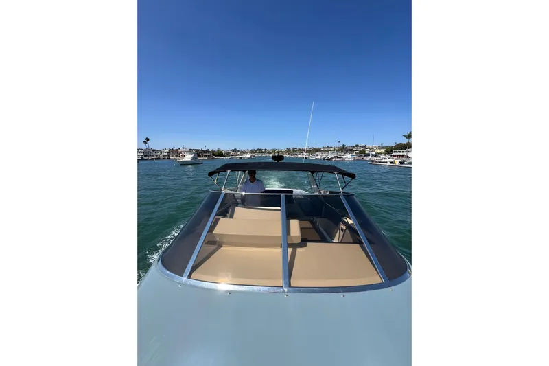 Fantom Yacht Photos Pics 1990 Tempest 60 Express boat cruising on a sunny day in a marina.