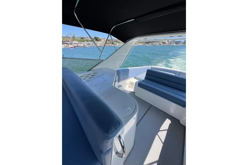 Fantom Yacht Photos Pics Interior view of 1990 Tempest 60 Express yacht with blue seating and ocean backdrop.