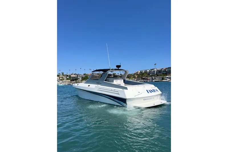 Fantom Yacht Photos Pics 1990 Tempest 60 Express yacht cruising on clear blue water.