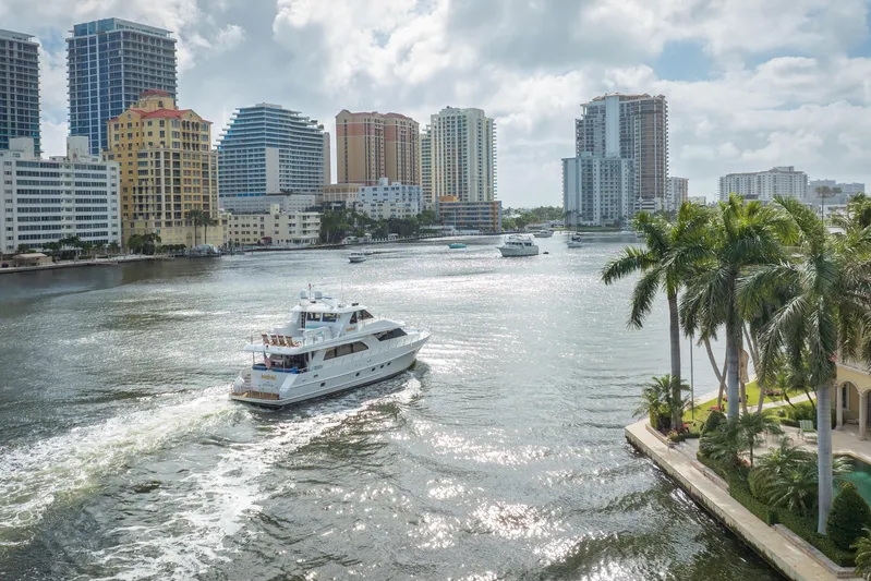  Yacht Photos Pics 2005 Ocean Alexander 80 Motoryacht cruising in a sunny urban waterway with skyscrapers.