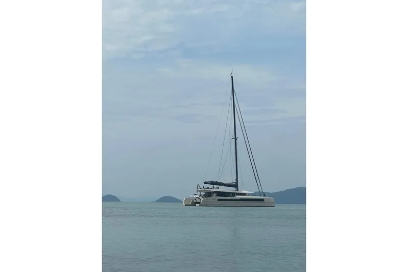 Jack Yacht Photos Pics 2023 McConaghy MC75 catamaran sailing on calm waters under a cloudy sky.