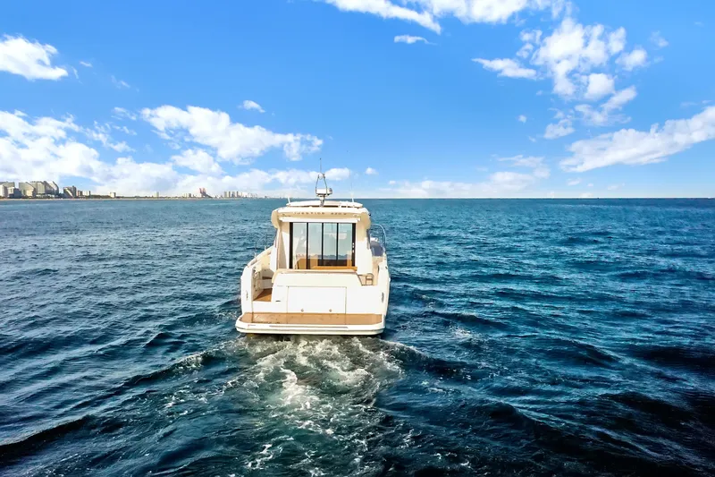 E Komo Mai Yacht Photos Pics 2022 Prestige 420S yacht cruising on open sea under clear blue sky.