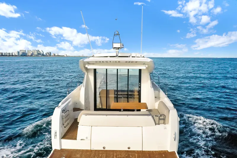 E Komo Mai Yacht Photos Pics 2022 Prestige 420S yacht cruising on open sea under clear blue sky.