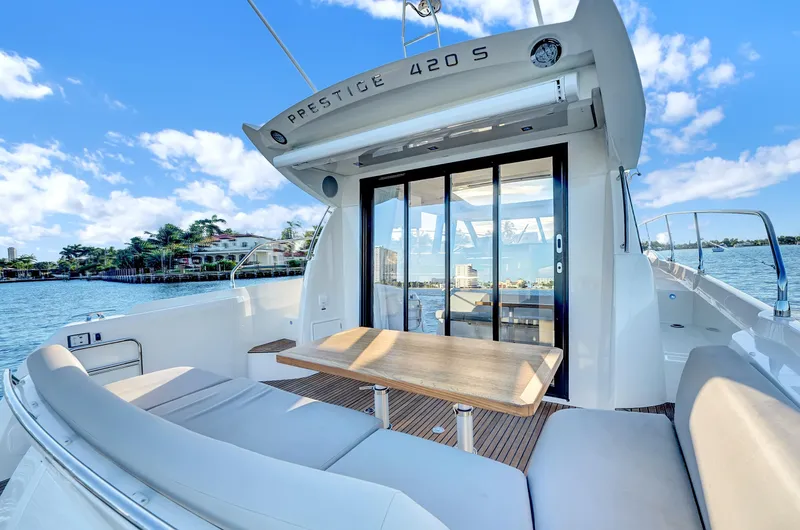 E Komo Mai Yacht Photos Pics Luxury 2022 Prestige 420S yacht with elegant seating and scenic ocean view.