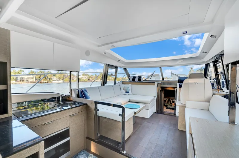 E Komo Mai Yacht Photos Pics Luxurious interior of 2022 Prestige 420S yacht with panoramic windows and modern furnishings.