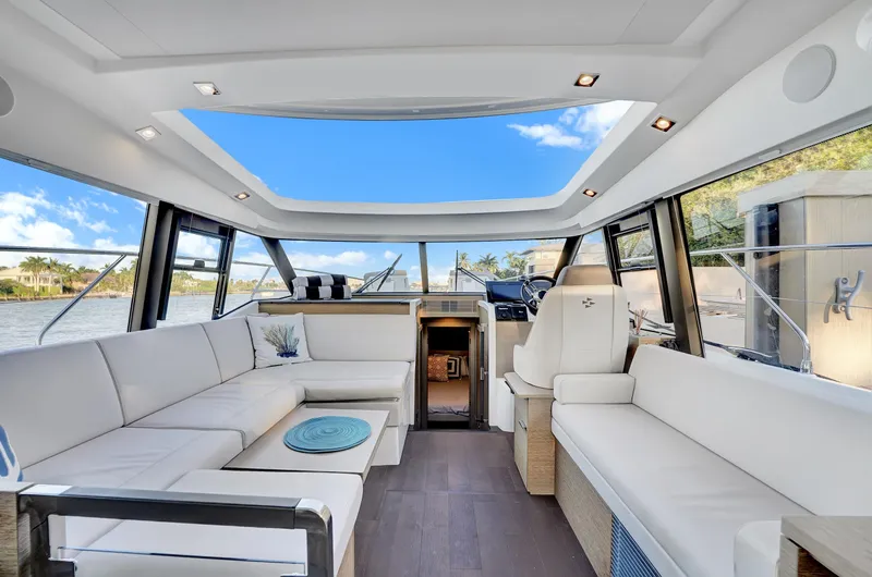 E Komo Mai Yacht Photos Pics Luxurious interior of 2022 Prestige 420S yacht with spacious seating and panoramic windows.