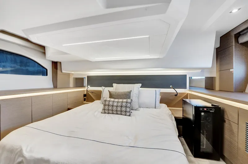 E Komo Mai Yacht Photos Pics Luxurious bedroom interior of 2022 Prestige 420S yacht with modern design and elegant bedding.