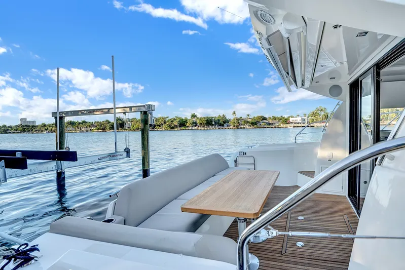 E Komo Mai Yacht Photos Pics Luxury 2022 Prestige 420S yacht with elegant deck seating and scenic waterfront view.