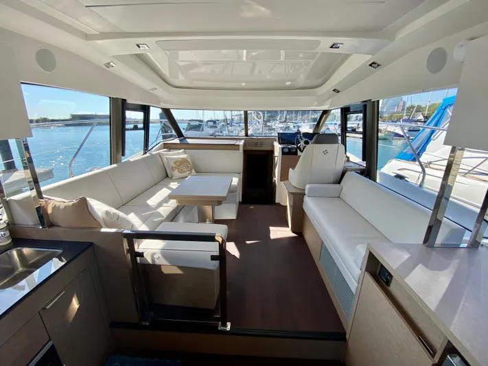 E Komo Mai Yacht Photos Pics Luxurious 2022 Prestige 420S yacht interior with elegant seating and panoramic windows.
