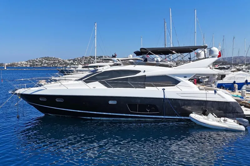  Yacht Photos Pics 2012 Sunseeker Manhattan 63 yacht docked in a marina, clear blue water and sky.