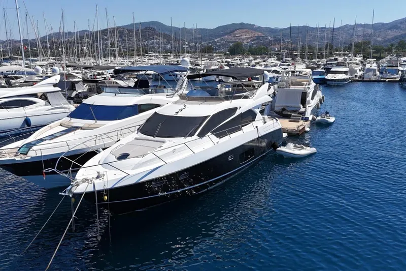  Yacht Photos Pics 2012 Sunseeker Manhattan 63 yacht docked in a marina, surrounded by other boats.