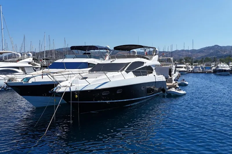  Yacht Photos Pics 2012 Sunseeker Manhattan 63 yacht docked in a marina, surrounded by other boats.