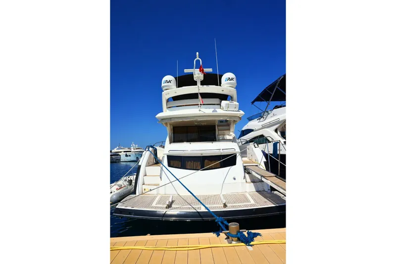  Yacht Photos Pics 2012 Sunseeker Manhattan 63 yacht docked at marina under clear blue sky.