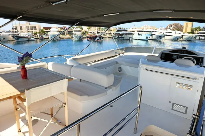  Yacht Photos Pics Luxurious 2012 Sunseeker Manhattan 63 yacht interior with seating and table, docked at marina.