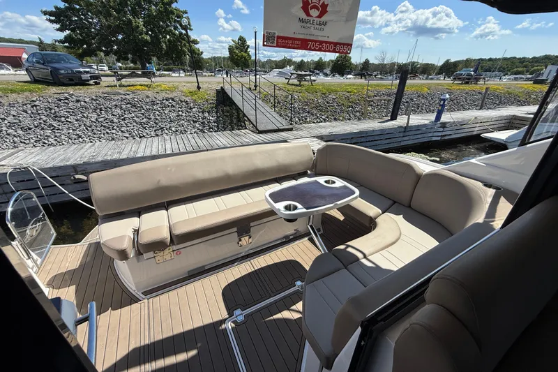  Yacht Photos Pics 2015 Regal 46 Sport Coupe yacht interior with beige seating and table, docked at marina.