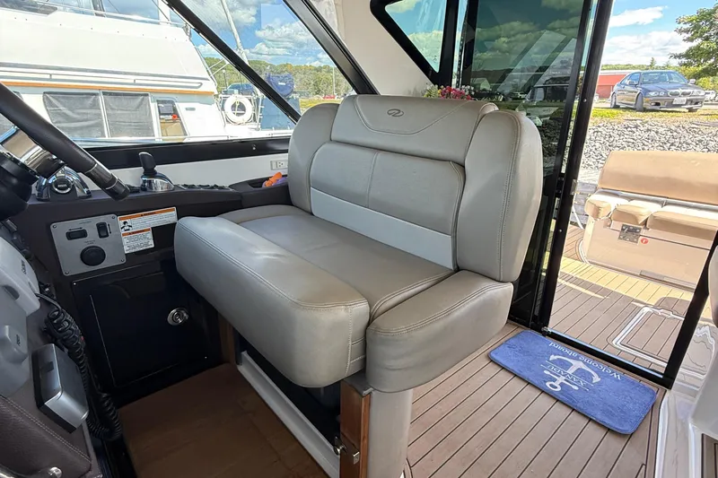  Yacht Photos Pics Captain's seat in 2015 Regal 46 Sport Coupe yacht cockpit, with view of marina.