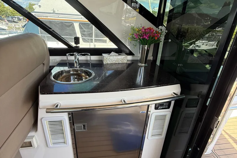  Yacht Photos Pics 2015 Regal 46 Sport Coupe interior with kitchenette, sink, and floral arrangement.